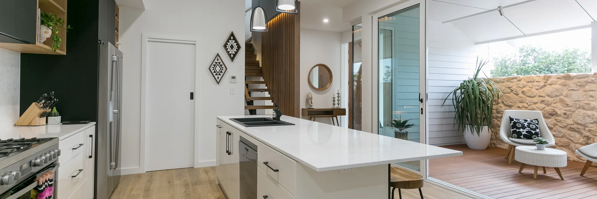 White cabinets throughout kitchen with black handles. Including a white island in the middle of the room.
