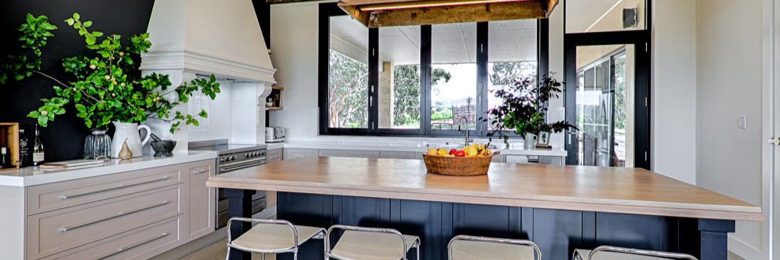 Farmhouse style kitchen with timber and black island in the middle of the room