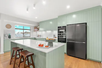 Contemporary kitchen renovation in Victor Harbor with mint green cabinets and white benchtops